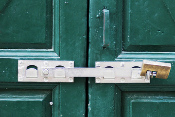 green wooden door with an iron lock