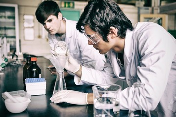 Male chemistry students making an experiment