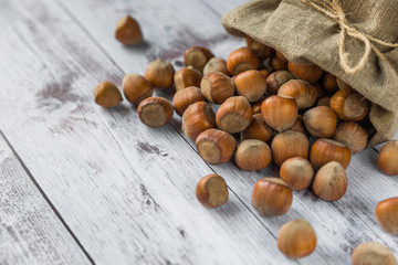 hazelnut on a white wooden background in a bag