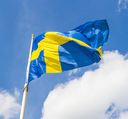 Swedish flag waving in the wind on a blue sky background