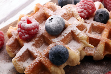 Traditional belgian waffles with fresh blueberries, sugar and raspberries.