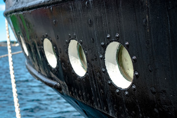 Obraz premium Close view of rounded porthole windows in the green side of the ship.