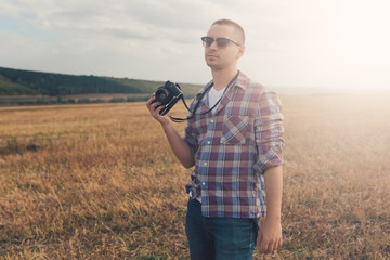 Attractive male photographer outdoors at sunset