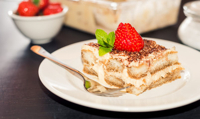 Homemade tiramisu cake decorated with strawberries Italian cuisine, Selective focus