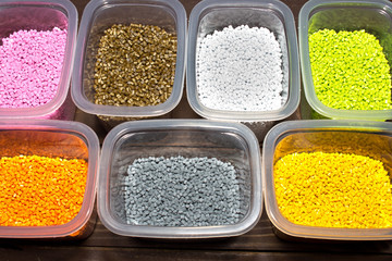 Plastic pellets. Colorful Polypropylene granules in a measuring container. Pigment in the granules.