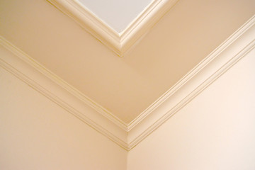 Room corner with a ceiling plinth in light tones