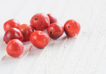 Heap of dried pink pepper berries on white wooden table. Close up view of pink peppercorn. Copy space.