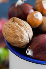 Chestnuts in white bowl on black background.