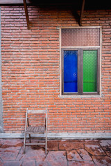 Fototapeta na wymiar chair and windows on brick wall