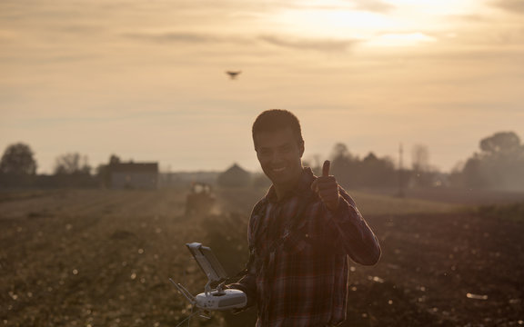 Farmer navigating drone above farmland