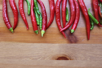 Red hot chilli peppers on the wooden table with copy space