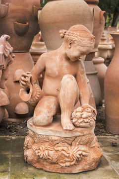 cstatue of nude young girl kneeling,  in Impruneta, Italy.