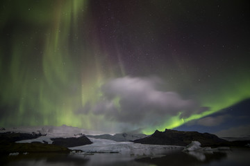 Fototapeta na wymiar Northern lights (aurora borealis) of the magnitude 8 over the Fjallsarlon Glacier Lagoon (Iceland) in November