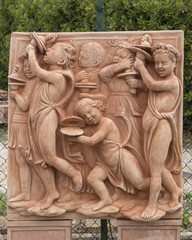 Terracotta half-relief of children with cymbals, in Impruneta, Italy