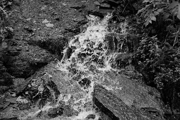 Water is broken about stones black and white photo
