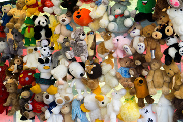 Children's colorful soft toys hanging on strings at a market