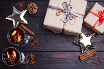 Mulled wine, gift boxes, spices and  decorations on dark wooden