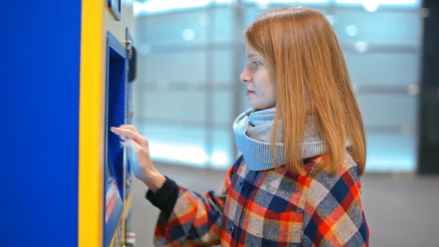 Young Lady is Buying a Ticket in Automatic Vending Machine, Paying by Credit Card using Paypass