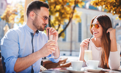 Romantic couple drinking coffee and lemonade, having a date in the cafe. Dating, love, relationships