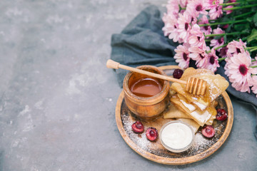 Fresh Homemade Pancakes with honey and flowers on vintage background. Top view