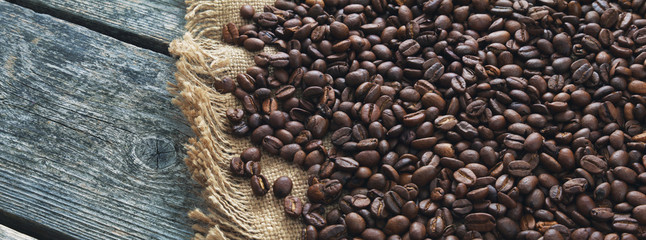 Panorama of coffee roasted grains on jute and wooden boards