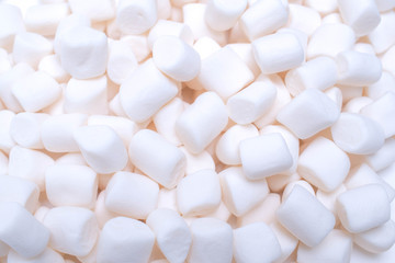 A lot of white mini marshmallows background close-up texture. Food background.