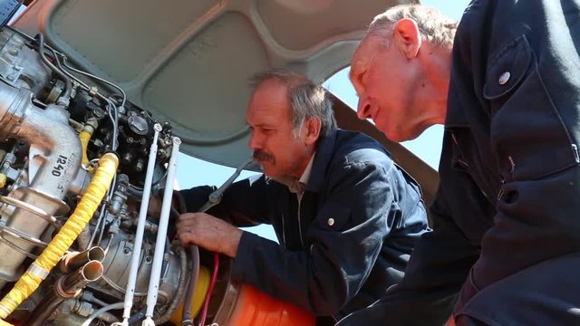Workers inspect the tubes in the motor.