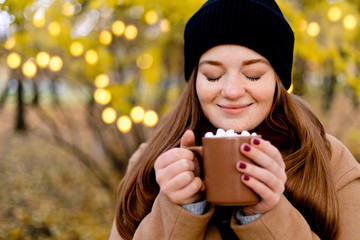 Girl drinks cocoa with marshmallow. Cozy winter morning, New Year's and Christmas holidays
