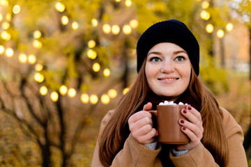Girl drinks cocoa with marshmallow. Cozy winter morning, New Year's and Christmas holidays