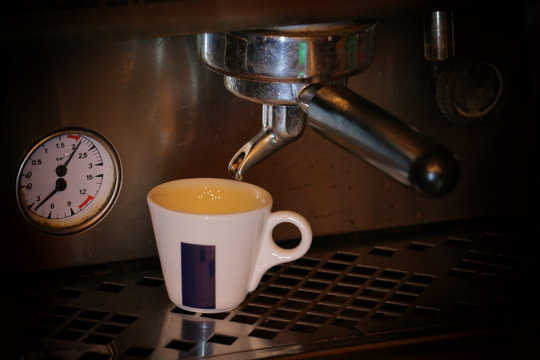 prepares espresso in his coffee shop; close-up
