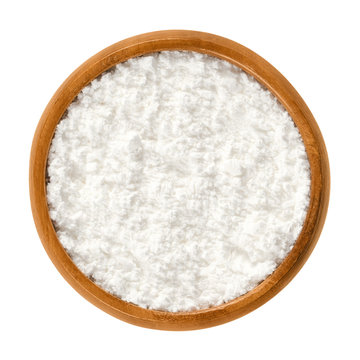 Powdered Sugar In Wooden Bowl. Unsifted Finely Ground White Refined Sugar. Also Called Confectioners Or Icing Sugar And Icing Cake. Isolated Macro Food Photo Close Up From Above On White Background.