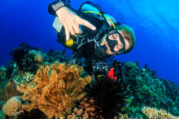 Plongeur sous-marin heureux sur un beau récif de corail tropical