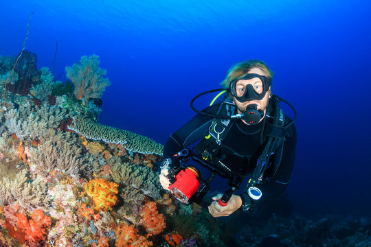 A SCUBA diver on a colorful, healthy tropical coral reef