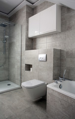 Furnished bathroom with white furniture, tiles in grey