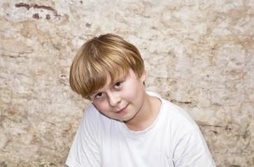 boy with light brown hair and brown eyes lookes friendly, happy and smiles