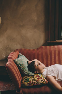 Profile of beautiful girl lying on vintage couch