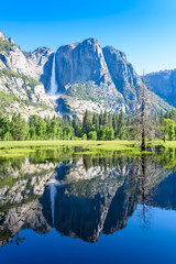 Fototapeta premium Yosemite National Park - Reflection in Merced River of Yosemite waterfall and beautiful mountain landscape, California, USA