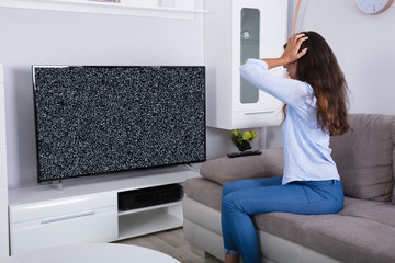 Woman Getting Frustrated With Glitch TV Screen