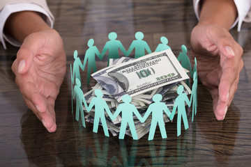 Hand Protecting Paper Cut Out Human Figures