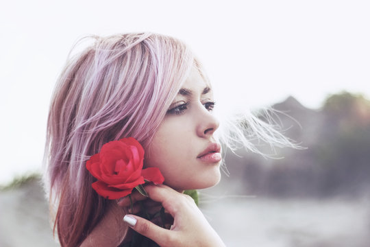 Beautiful girl holding rose in her hand