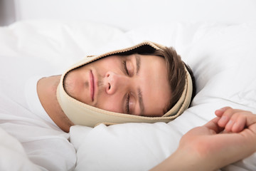 Man Sleeping With Anti Snoring Bandage