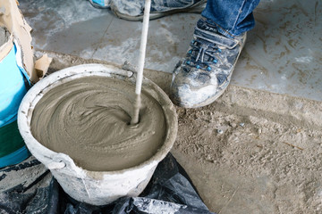 Mixing cement with a mixer in a bucket on the street