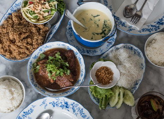 group of various local aisa food served with rice on chinese blue pattern white plate