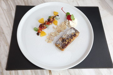 Fruitcake on white plate and decorative topping, American Style Luxury Restuarant