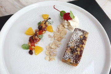 Fruitcake on white plate and decorative topping, American Style Luxury Restuarant