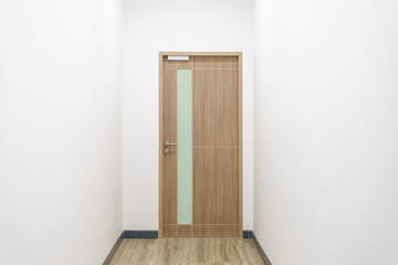 Close up of closed wooden door in the empty room with copy space