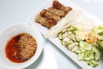 Vietnamese Food in Restaurant white plate on the Table with side dish, Spring rolls with vegetables and in noodle tube pork tao fu inside