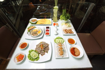 Vietnamese Food in Restaurant white plate on the Table with side dish, Spring rolls with vegetables and in noodle tube pork tao fu inside