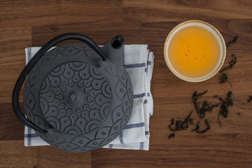 Image of traditional eastern teapot and teacups on wooden desk 