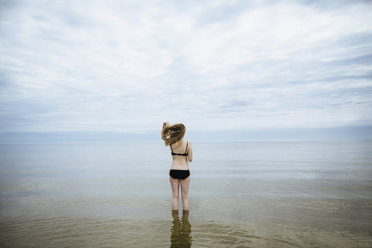 Blond woman in bathing suit standing in water